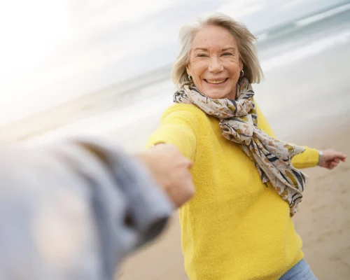 Fröhliche Seniorin am Strand