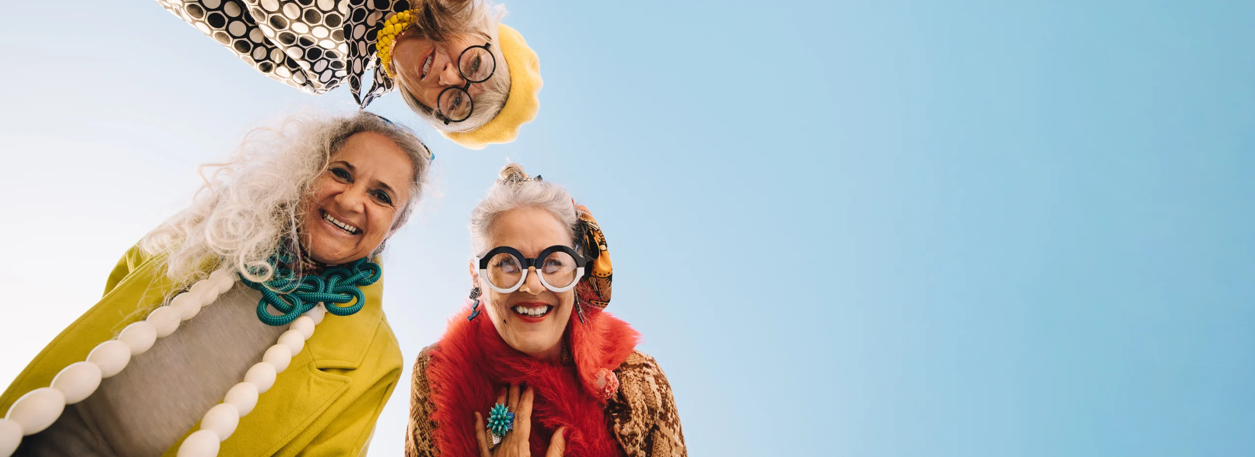 Drei Menschen schauen lächelnd in die Kamera